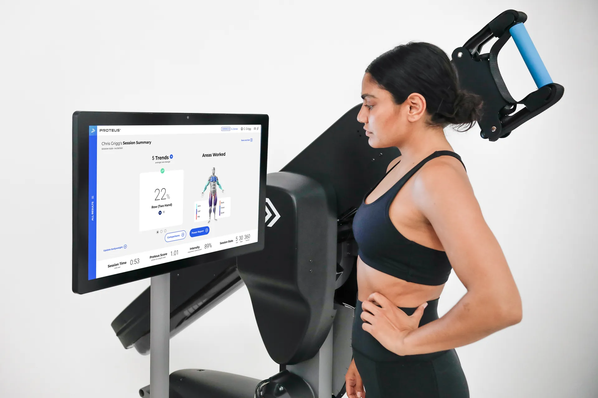 A client training on a Proteus machine beside its kiosk showing a live session summary
